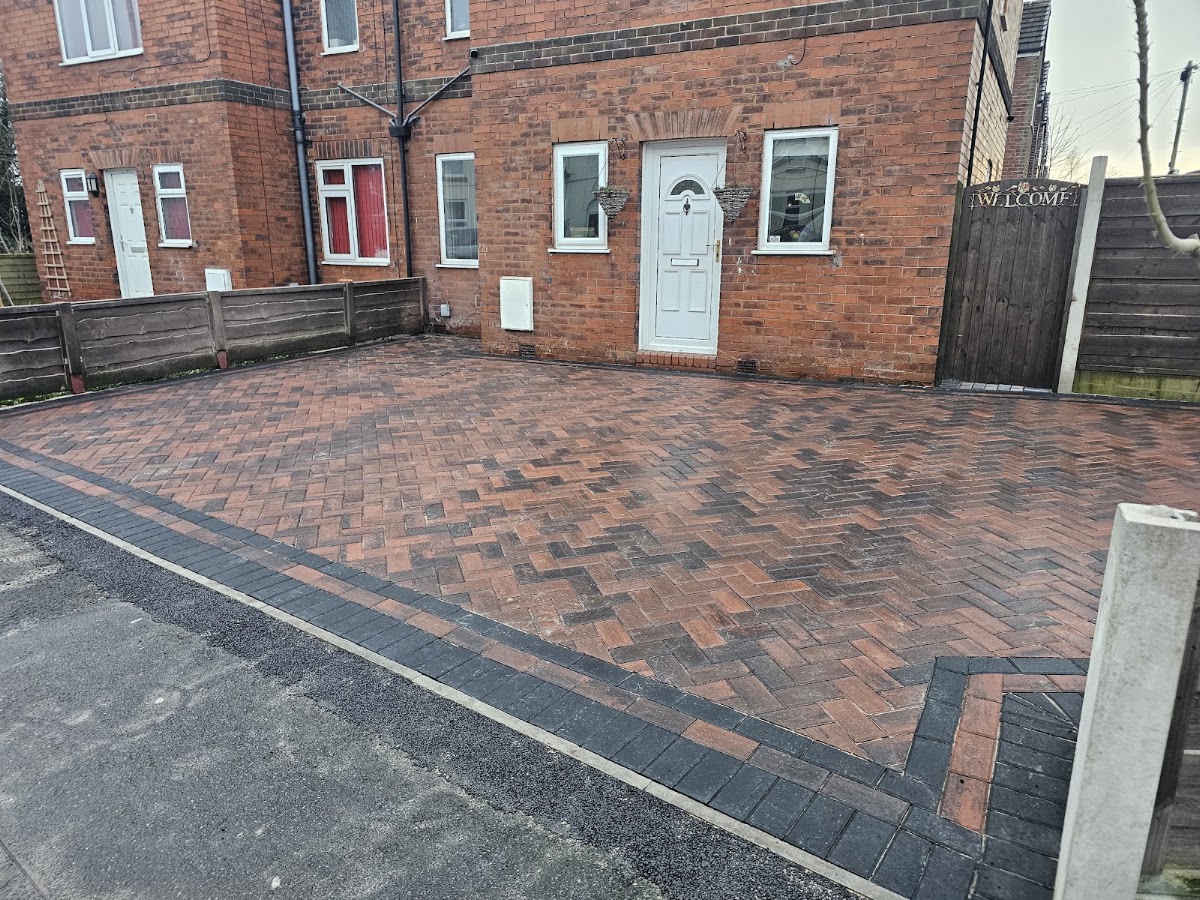 Red brindle block paved driveway with a charcoal double border, laid herringbone
