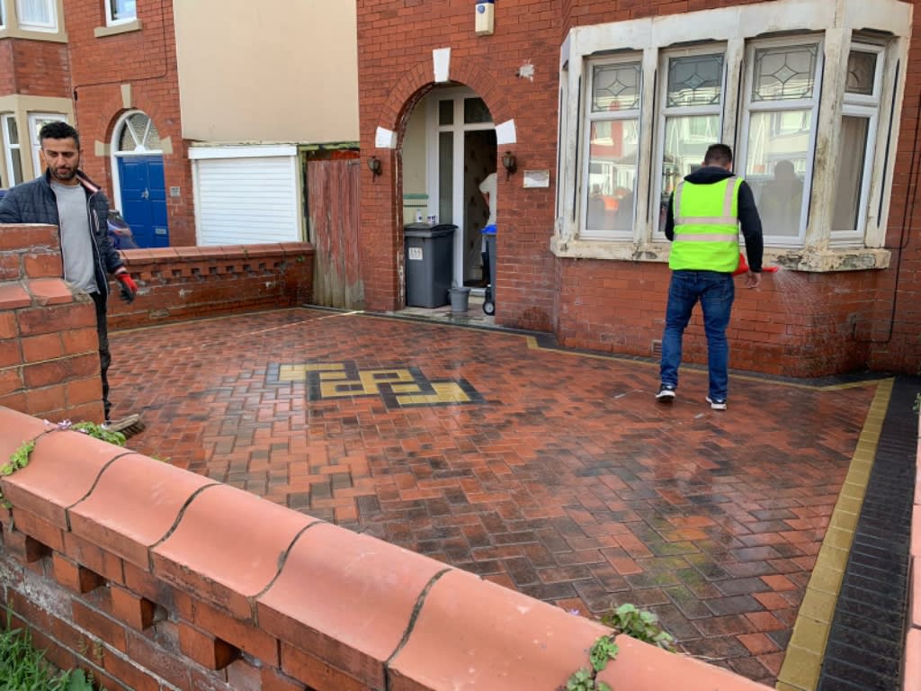 The team finishing a red block paved front driveway with a feature key pattern